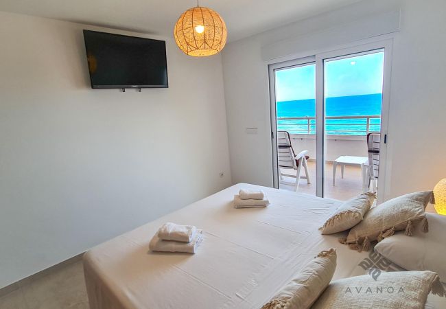 Bedroom with twin beds side by side with sea view and TV.